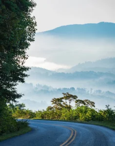 Scenic Blue Ridge Parkway overlook with misty mountain views at sunrise.